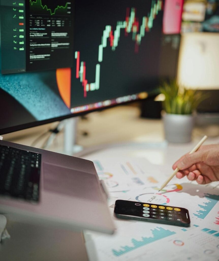 Investment analyst reviewing market charts and portfolio data for private investment advisory decisions.